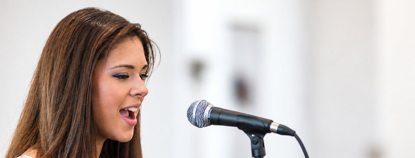 Teilnehmerin eines Vocalpower-Gesangsworkshops singt am Mikrofon