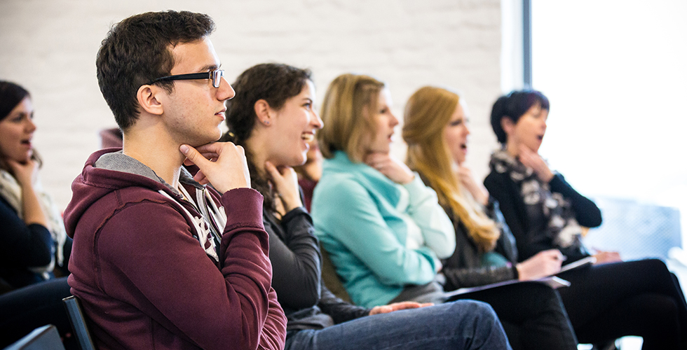 Teilnehmer üben gemeinsam Stimmübungen