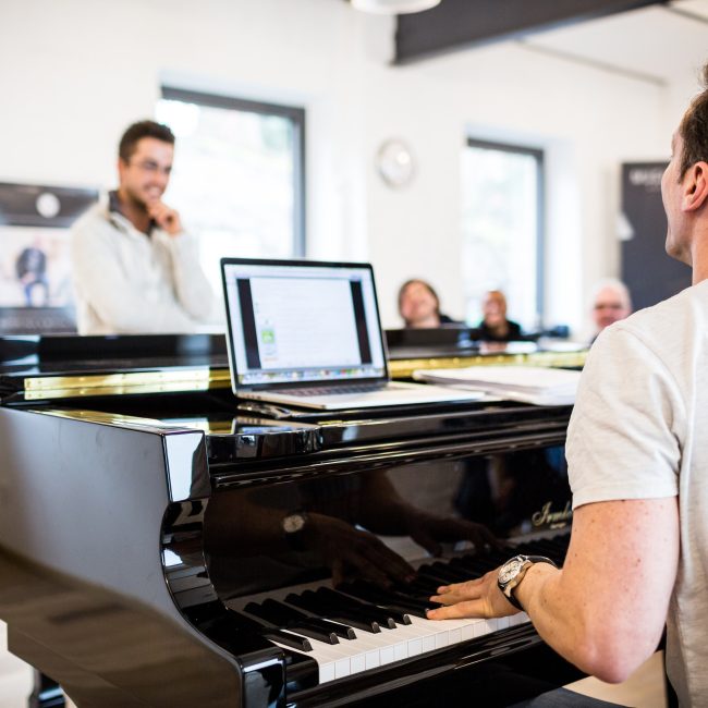Mischa unterrichtet einen Gesangsschüler am Piano