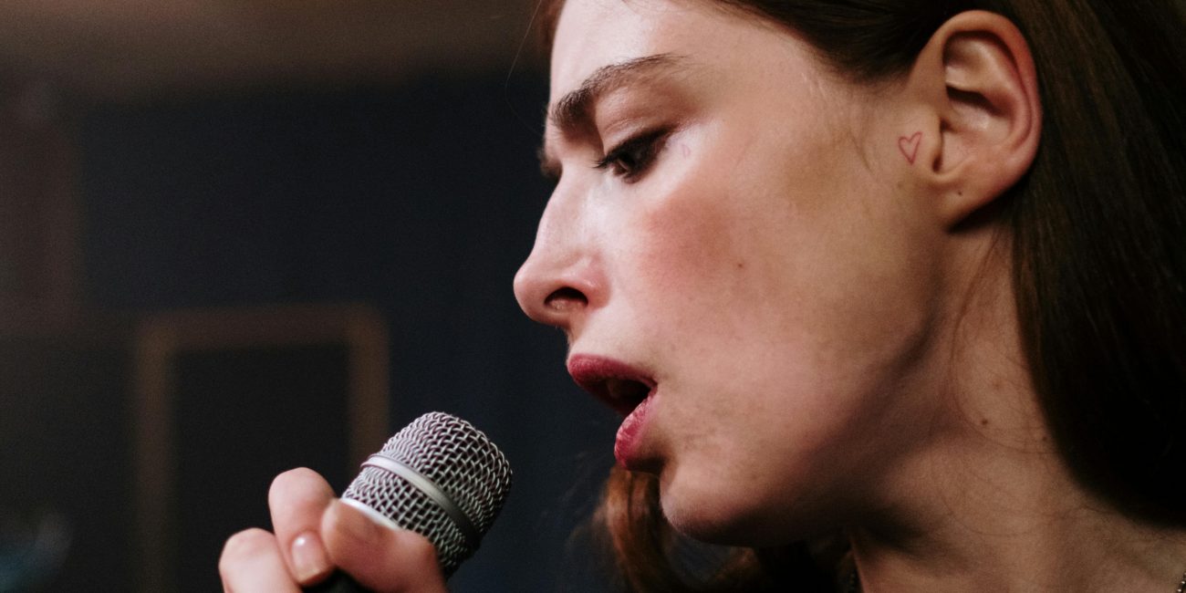 Eine Gesangsschülerin singt in ein Mikrofon