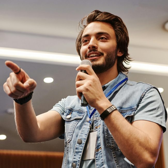 Ein junger Gesangslehrer bringt schwungvoll seinem Publikum etwas bei