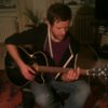 Musiker an der Gitarre und spielt einen Song